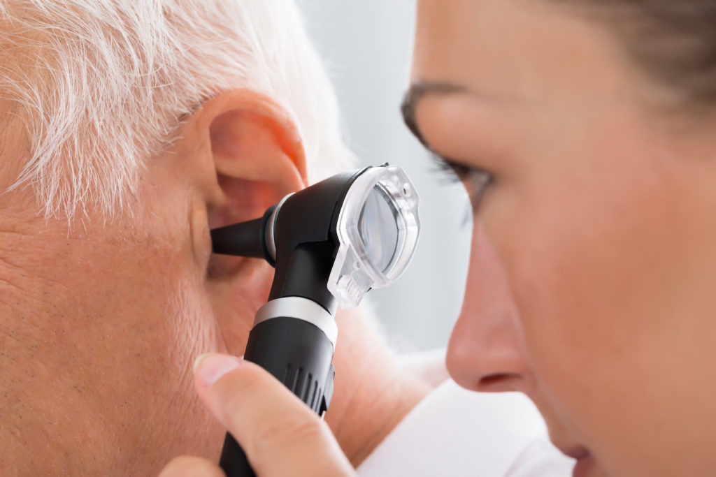 Close-up Of Female Doctor Examining Patient's Ear With Otoscope