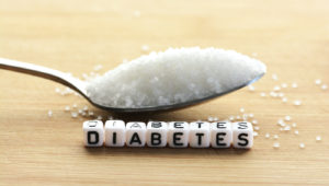 Diabetes block letters in crossword and sugar pile on a spoon