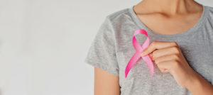 Woman holding pink ribbon to her chest