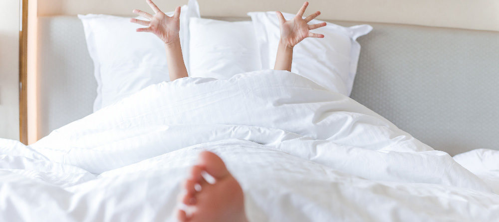 Person lounging in a crisp clean bed