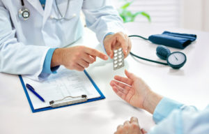 Doctor handing pills to a patient