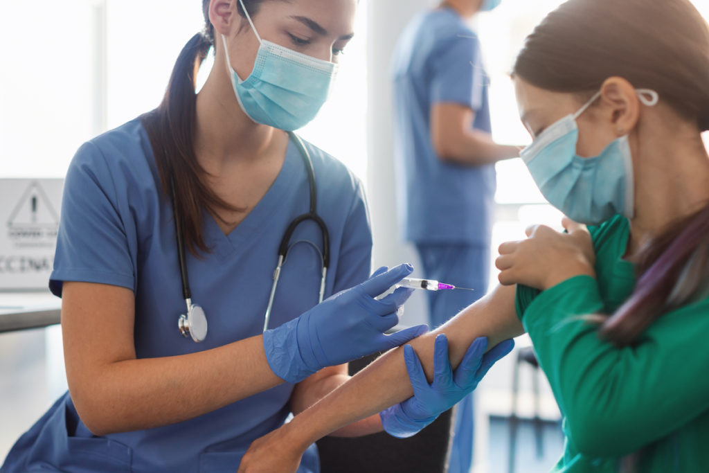 Girl receiving live attenuated vaccine to reduce impact of COVID-19