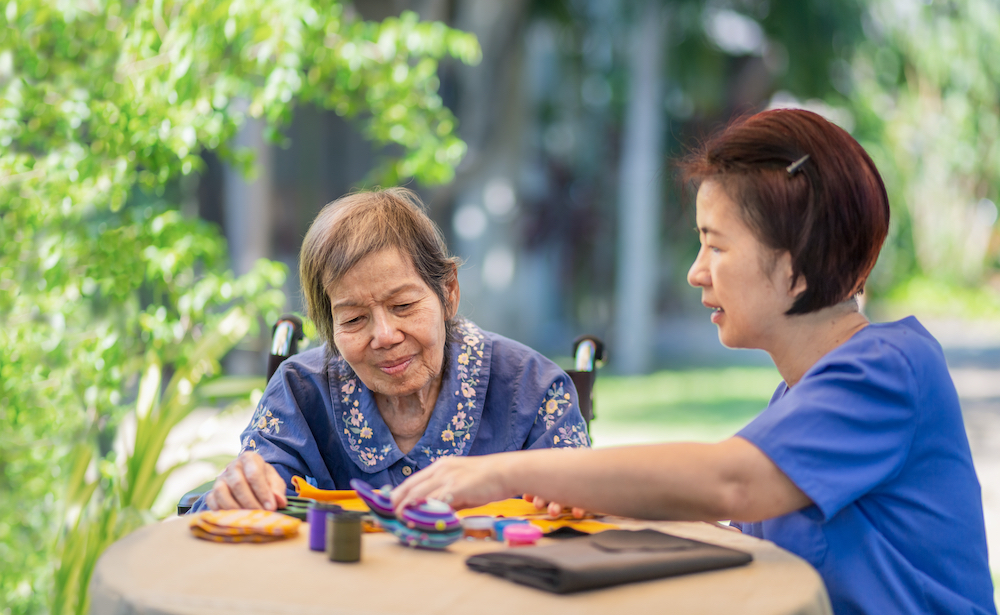 Elderly woman with caregiver doing occupational therapy for Alzheimers or dementia
