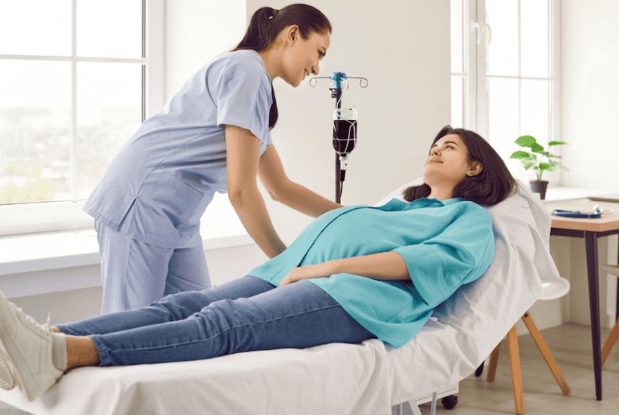 A pregnant woman receiving an iron infusion from a nurse