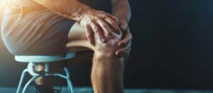 Man holding knee in pain as result of osteoarthritis, illustrating metformin treatment