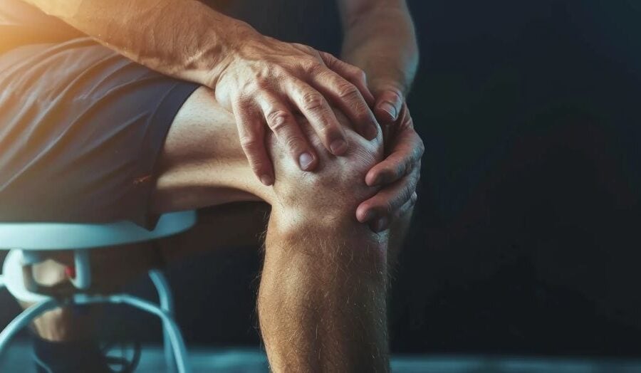 Man holding knee in pain as result of osteoarthritis, illustrating metformin treatment