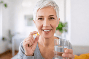 Mature woman holding a capsule of vitamin D