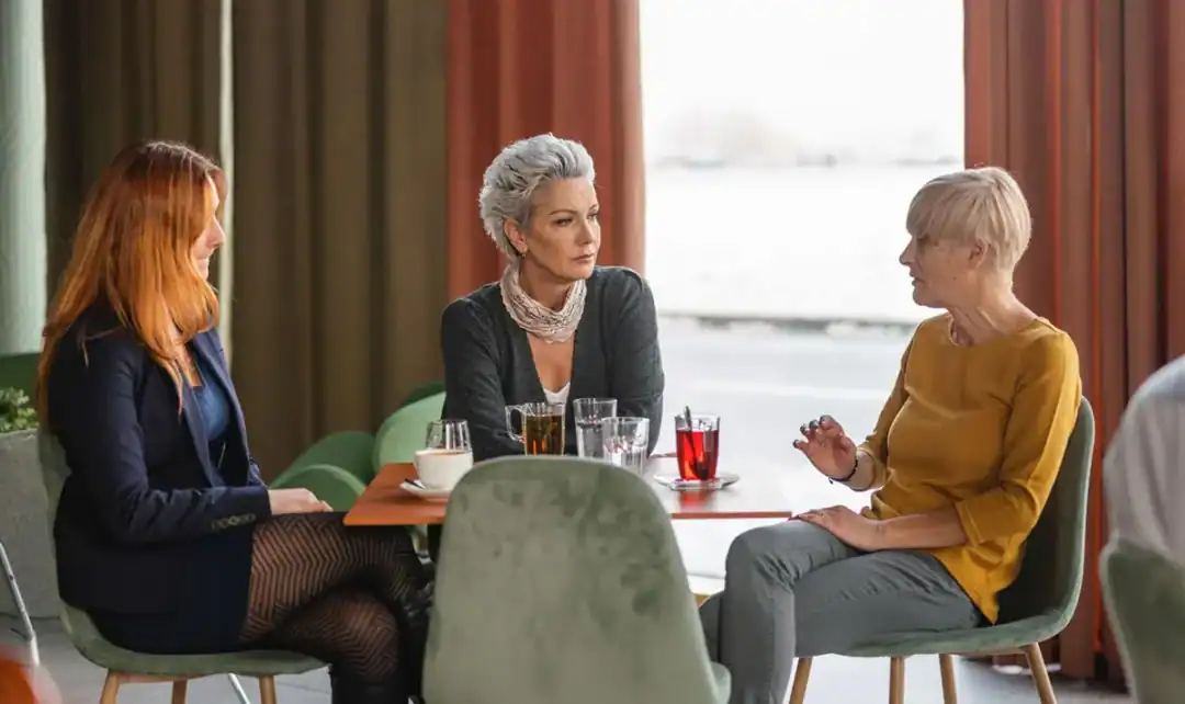 Middle aged women sitting around a table discussing nonhormonal menopause treatment